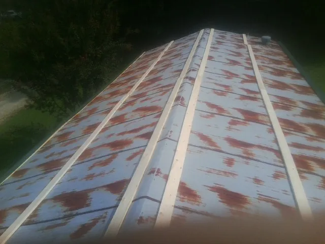 Rusted metal roof panels with new wood purlins before replacement — Storm Damage Roof Repair in Solomons by Roofing Brothers